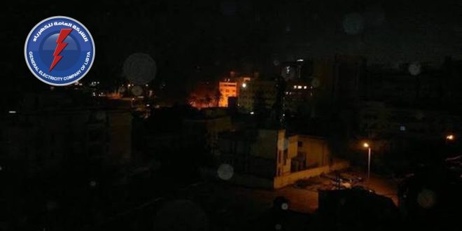 ​صورة ليلية لمنطقة سكنية مظلمة مع شعار الشركة العامة للكهرباء، تعبيرًا عن آلاف بلاغات الأعطال وانقطاع التيار.
