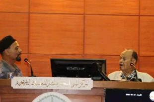 ​صورة فوتوغرافية للفنان والمصمم الليبي محمد علي سيالة أثناء تحدثه في الجلسة الحوارية "الطابع البريدي ذاكرة مرسومة" بمقر المركز الليبي للمحفوظات والدراسات التاريخية.