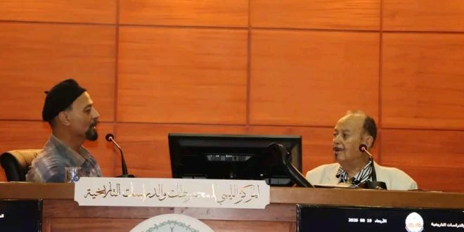 ​صورة فوتوغرافية للفنان والمصمم الليبي محمد علي سيالة أثناء تحدثه في الجلسة الحوارية "الطابع البريدي ذاكرة مرسومة" بمقر المركز الليبي للمحفوظات والدراسات التاريخية.