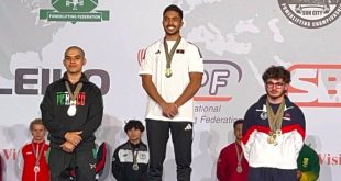 البطل الليبي محمد الساحلي يقف على منصة التتويج المركز الأول متقلدًا الميدالية الذهبية لبطولة العالم للقوة البدنية لوزن 66 كجم ناشئين بجانب الفائزين بالمركزين الثاني والثالث.