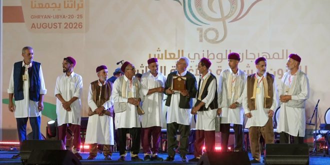 رئيس الهيئة العامة للسينما والمسرح والفنون عبد الباسط بوقندة يكرّم أعضاء فرقة فلكلورية ترتدي الزي التقليدي الليبي على المسرح خلال المهرجان الوطني العاشر للفنون الشعبية في غريان.