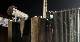 صورة ليلية لمحطة تحويل كهربائية متضررة بشدة بعد انقطاع التيار الكهربائي في المنطقة الغربية. يظهر محول كبير متفحم وسط الهياكل المعدنية، مع آثار دخان وحرارة واضحة على المكونات وأنابيب التبريد. في الخلفية، يقف برج نقل كهربائي في الظلام. الصورة توضح الأضرار المرتبطة بالإظلام الجزئي والتحقيق الجاري من قبل الشركة العامة للكهرباء.