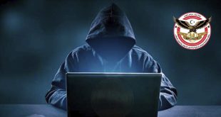 صورة تعبيرية تظهر شخصاً مجهول الهوية يرتدي غطاء رأس (هودي) أسود ويجلس أمام جهاز كمبيوتر محمول (لابتوب