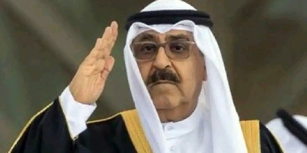 أمير دولة الكويت الشيخ مشعل الأحمد الجابر الصباح يرتدي الزي التقليدي ويرفع يده بالتحية.