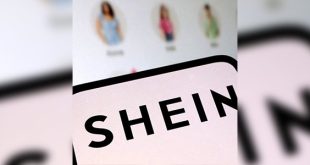 شعار منصة الأزياء السريعة "شي إن" (SHEIN) باللون الأسود على خلفية فاتحة، وتظهر خلفه شاشة تعرض منتجات أزياء