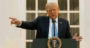 الرئيس الأميركي دونالد ترامب يقف خلف منصة عليها شعار الرئاسة، ملوحًا بييده ومؤشرًا بسبابته أثناء إلقاء كلمة.