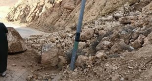 صخور وأتربة ممتدة من منحدر جبلي تغلق طريقًا زفتيًا مع وجود عمود إنارة وسقوط أحجار ضخمة