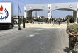 صورة مجمعة تظهر عناصر مسلحة من حرس المنشآت النفطية يقفون عند بوابة مصفاة الزاوية المغلقة بالحواجز، مع إدراج شعار المؤسسة الوطنية للنفط في الزاوية العلوية