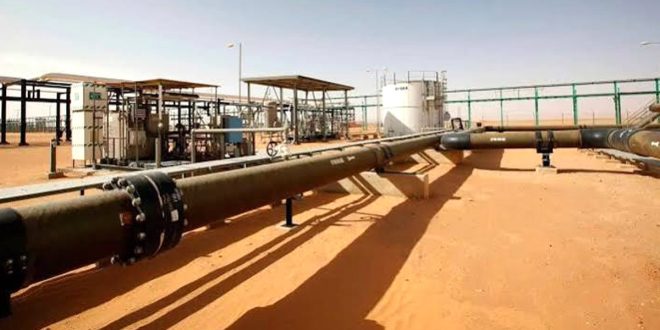 أنابيب ونشآت نفطية ممتدة في منطقة صحراوية تتبع خطوط نقل النفط الخام.