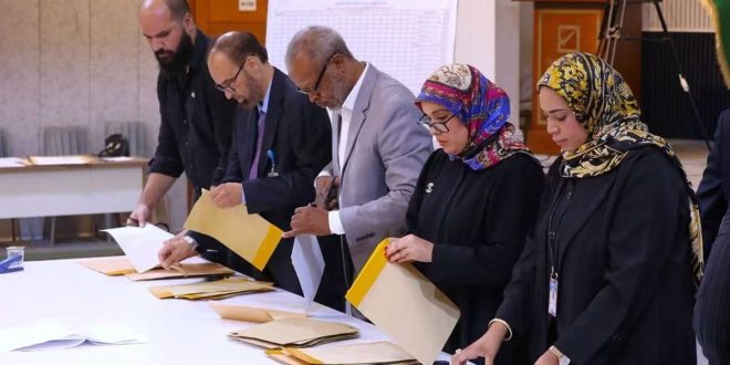 أعضاء لجنة الانتخابات يقفون بجانب طاولة فرز الأصوات أثناء فتح المغاريف واستخراج أوراق الاقتراع الخاصة بانتخابات النقابة العامة للمعلمين في ليبيا.