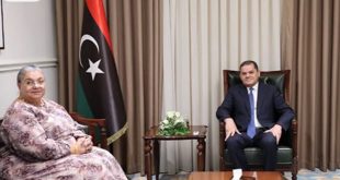 رئيس حكومة الوحدة الوطنية عبد الحميد الدبيبة يجلس في مكتبه وبجانبه الممثلة الخاصة للأمين العام للأمم المتحدة هانا تيتيه وبينهما العلم الليبي خلال لقاء لبحث المسار السياسي.