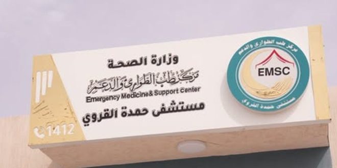​صورة مقربة للافتة بيضاء لمدخل مستشفى حمدة القروي ببلدية الجميل، تحمل شعار "مركز طب الطوارئ والدعم" ووزارة الصحة الليبية، وتعلن عن بدء التشغيل التجريبي للمستشفى بإشراف "مركز طب الطوارئ والدعم"