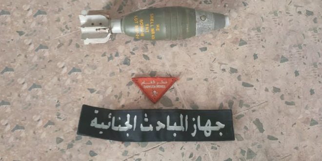 قذيفة هاون عيار 60 ملم تم انتشالها من منطقة السياحية بطرابلس بجانبها علامة تحذيرية وشريط يخص جهاز المباحث الجنائية.