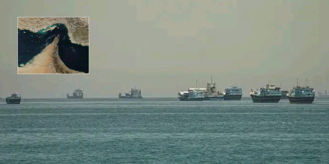 سفن تجارية وبحرية ترسو في مياه الخليج بالقرب من مضيق هرمز، مع خريطة مصغرة للمضيق تعبيرًا عن أزمة الملاحة وتراجع حركة التجارة والطاقة.