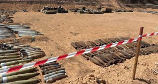 صفوف من آلاف الذخائر المتفجرة التي تم إزالتها من مزرعة السويحلي في مصراتة، مصفوفة على الأرض خلف شريط تحذيري، في عملية أشرفت عليها الأمم المتحدة.