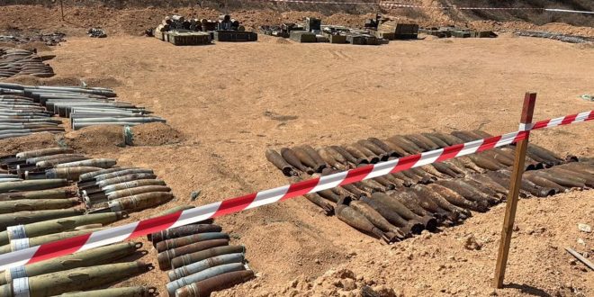 صفوف من آلاف الذخائر المتفجرة التي تم إزالتها من مزرعة السويحلي في مصراتة، مصفوفة على الأرض خلف شريط تحذيري، في عملية أشرفت عليها الأمم المتحدة.