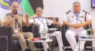 ثلاثة ضباط برتب عسكرية يرتدون الزي الرسمي يجلسون على منصة أثناء ندوة،