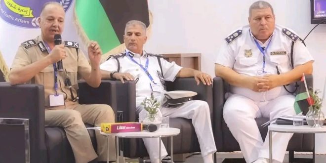 ثلاثة ضباط برتب عسكرية يرتدون الزي الرسمي يجلسون على منصة أثناء ندوة،