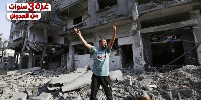 رجل فلسطيني يقف وسط ركام المباني والدمار في غزة رافعاً يديه إلى السماء، ويظهر أعلى يسار الصورة شعار نصي "غزة 3 سنوات من العدوان