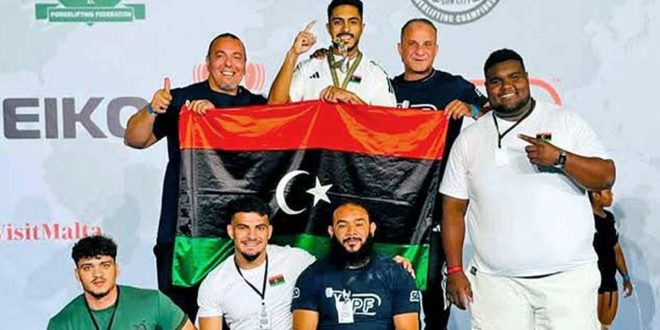 صورة جماعية لأعضاء وطاقم المنتخب الليبي للقوة البدنية يحملون علم ليبيا ويحتفلون بإنجازاتهم الرياضية.