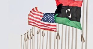 العلم الليبي والعلم الأمريكي يرفرفان جنباً إلى جنب على ساريتين في الهواء الطلق