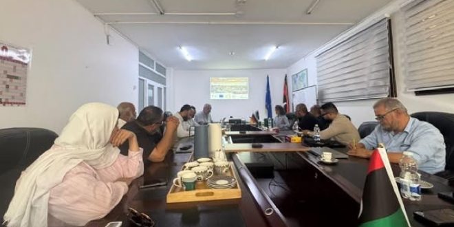 اجتماع عمل للجان القطاعية المعنية بالتغير المناخي بمقر الوكالة الألمانية للتعاون الدولي يتوسطه العلم الليبي وعلم ألمانيا وعرض مرئي في خلفية القاعة.