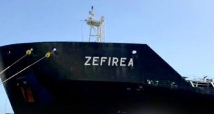 مقدمة السفينة أو الناقلة النفطية السوداء "ZEFIREA" ملتحمة ومربوطة بحبال الرسو على الرصيف البحري تحت السماء الصافية.