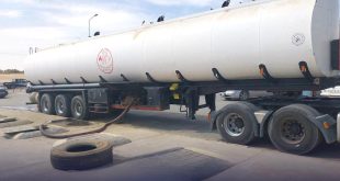 شاحنة نقل وقود ضخمة بيضاء اللون أثناء تفريغ حمولتها في محطة وقود بمدينة جالو إثر ضبطها من قبل قسم البحث الجنائي بمديرية أمن الواحات.