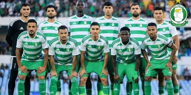 صورة جماعية للاعبي فريق الأهلي طرابلس بزيّهم الرسمي ذي الخطوط الخضراء والبيضاء والشعار الرسمي للنادي أعلى اليسار.
