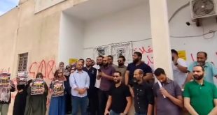 صورة لمجموعة من الأطباء والطبيبات خلال وقفة احتجاجية أمام مقر النقابة العامة للأطباء في منطقة بن عاشور بطرابلس وهم يرفعون اللافتات.