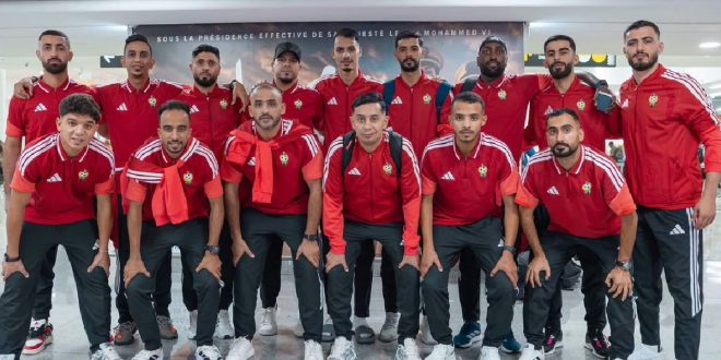 صورة جماعية لأعضاء ولاعبي المنتخب الوطني لكرة القدم داخل الصالات يرتدون الزي الرياضي في المطار عند وصولهم إلى المغرب.
