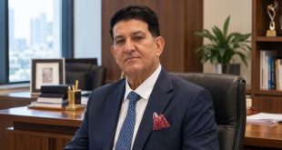 ​صورة للدكتور محمد شرف الدين الفيتوري، أستاذ الإعلام، في مكتبه، يرتدي بدلة زرقاء وربطة عنق، وذلك في سياق خبر عودته لمنزله بعد أسبوع من الغياب