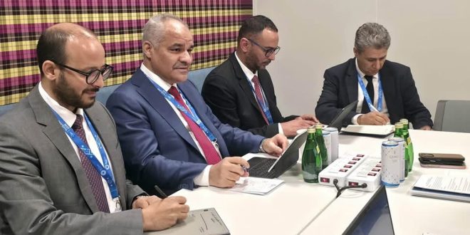 ​صورة فوتوغرافية تظهر محافظ مصرف ليبيا المركزي ناجي محمد عيسى وأعضاء وفده يشاركون في اجتماع رسمي على طاولة عليها حواسيب ومستلزمات مكتبية، لمناقشة تعزيز التعاون مع وزارة الخزانة الأمريكية في بانكوك، تايلاند.