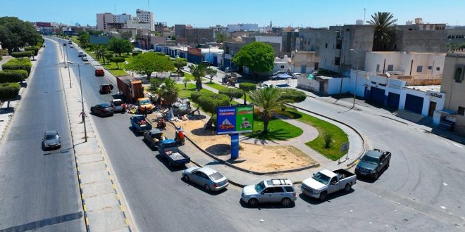 صورة جوية لشارع عام في منطقة السياحية بطرابلس تظهر فيه حركة المرور وموقع أعمال الصيانة الطارئة لمعالجة هبوط خط الصرف الصحي.