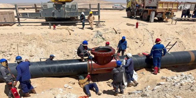 : مهندسون وفنيون يعملون في موقع صحراوي على استبدال وربط خط الشحن الرئيسي لنقل النفط بين حقل السرير وميناء الحريقة