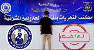 ​صورة توثيقية لمشتبه به يقف بظهره أمام لوحة رسمية لجهاز المباحث الجنائية (مكتب التحريات بالمنطقة الحدودية الشرقية طبرق)، مرفقة بختم "تم القبض" وشعار الجهات الأمنية.