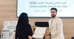 ​شاب يقدم شهادة تقديرية لطالبة خلال احتفالية جامعة أجدابيا باليوم العالمي للصحة النفسية 2026