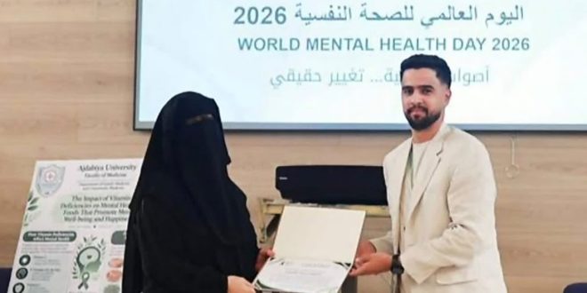 ​شاب يقدم شهادة تقديرية لطالبة خلال احتفالية جامعة أجدابيا باليوم العالمي للصحة النفسية 2026