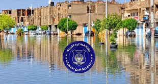صورة فوتوغرافية لتجمعات مياه الأمطار تغمر شوارع مدينة سبها مع شعار مديرية أمن سبها في المقدمة