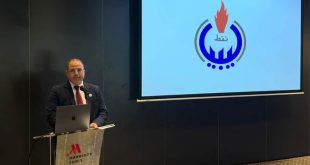​متحدث يلقي كلمة خلال ورشة عمل لتقييم انبعاثات الميثان، وأمامه شاشة عرض تحمل شعار المؤسسة الوطنية للنفط في ليبيا.