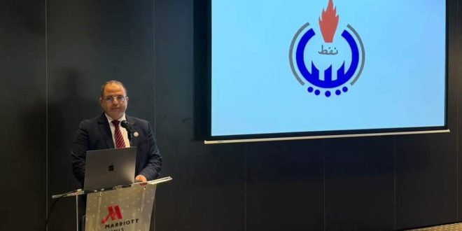 ​متحدث يلقي كلمة خلال ورشة عمل لتقييم انبعاثات الميثان، وأمامه شاشة عرض تحمل شعار المؤسسة الوطنية للنفط في ليبيا.