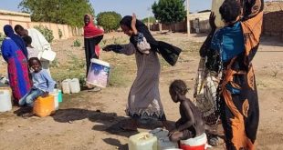 ​"صورة لأطفال ونساء سودانيين في منطقة متأثرة بالصراع، تعبيرًا عن تداعيات هجمات المسيرات والنزوح."