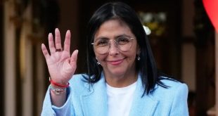 ​صورة للرئيسة الفنزويلية بالوكالة ديلسي رودريغيز ترتدي سترة زرقاء وتلوح بيدها.