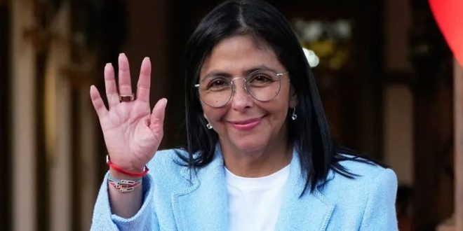 ​صورة للرئيسة الفنزويلية بالوكالة ديلسي رودريغيز ترتدي سترة زرقاء وتلوح بيدها.