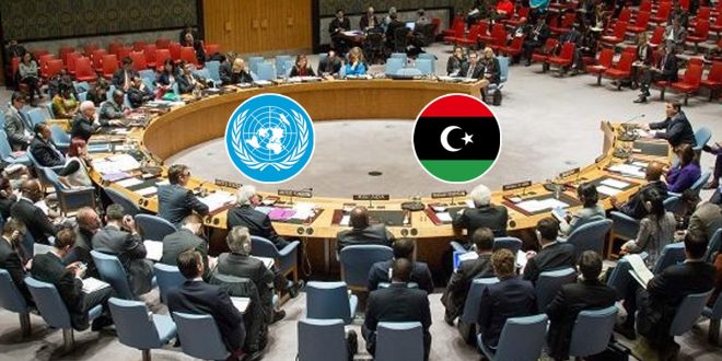 صورة قاعة اجتماعات الأمم المتحدة الدائرية مع شعاري الأمم المتحدة وعلم ليبيا في المنتصف، وأعضاء الوفود يجلسون على الطاولة المستديرة.