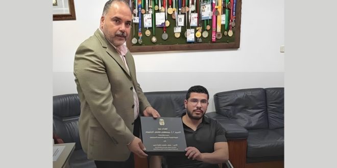 صورة لرئيس لجنة إدارة صندوق التضامن الاجتماعي وهو يقدّم درع تكريم للبطل طيف عثمان حافظ الحائز على ذهبية بطولة أفريقيا لرافعات القوة.