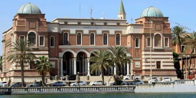 صورة خارجية لمبنى مصرف ليبيا المركزي التاريخي في العاصمة طرابلس مع الواجهة المعمارية المميزة والأعمدة والأقواس والأشجار أمامها