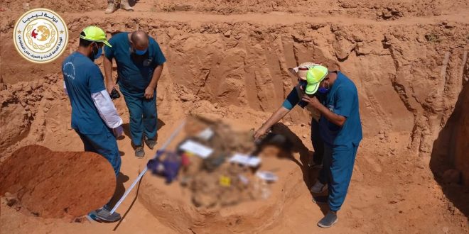 صورة لفريق الهيئة العامة للبحث والتعرف على المفقودين أثناء أعمال التنقيب واستخراج رفات الضحايا من إحدى المقابر الجماعية في ترهونة.